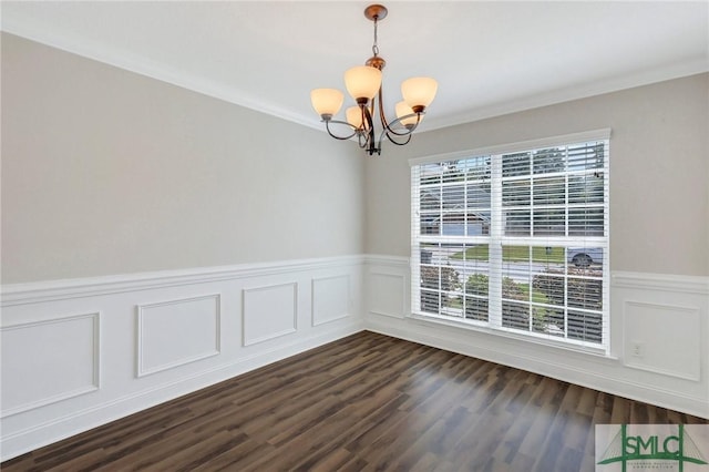 spare room featuring wainscoting, dark wood-style flooring, a decorative wall, and a chandelier