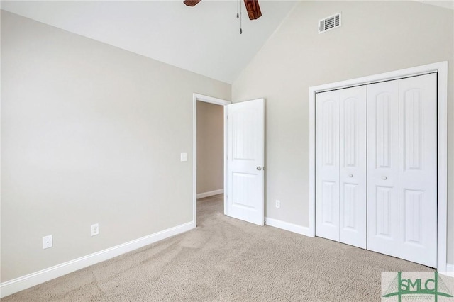 unfurnished bedroom featuring carpet flooring, high vaulted ceiling, baseboards, visible vents, and a closet
