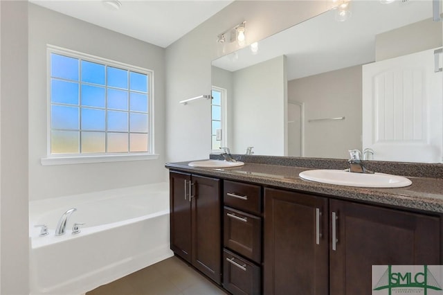 full bathroom with a sink, a garden tub, and double vanity