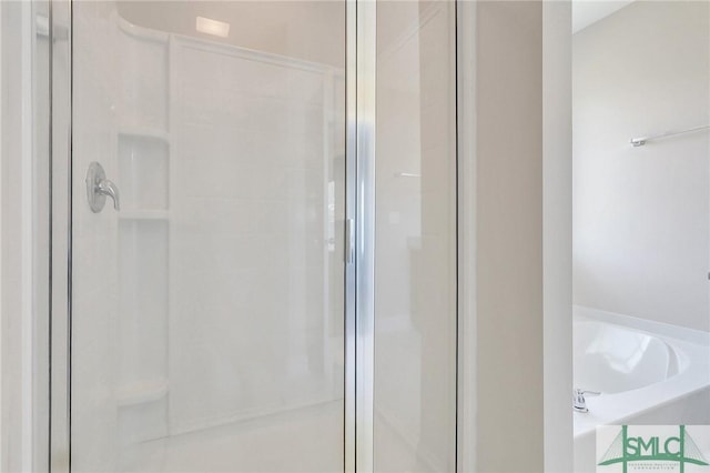 bathroom with a shower stall and a garden tub