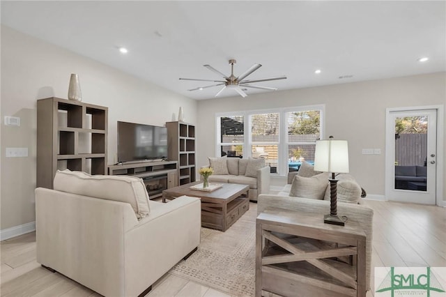 130 Canter Ct, Savannah, GA 31406 - living room with a ceiling fan, recessed lighting, a glass covered fireplace, baseboards, and light wood-type flooring