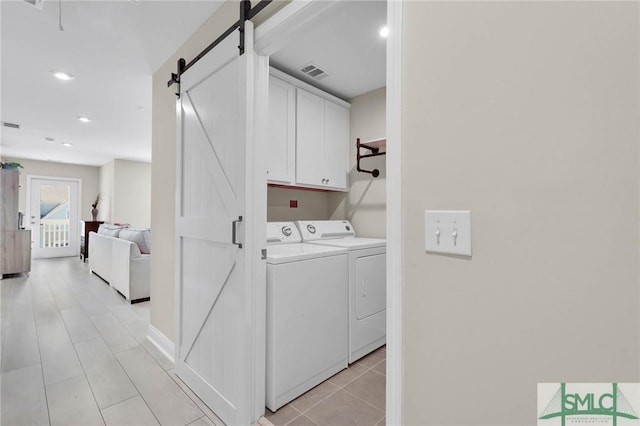 130 Canter Ct, Savannah, GA 31406 - laundry area featuring washer and clothes dryer, cabinet space, a barn door, recessed lighting, and light tile patterned floors