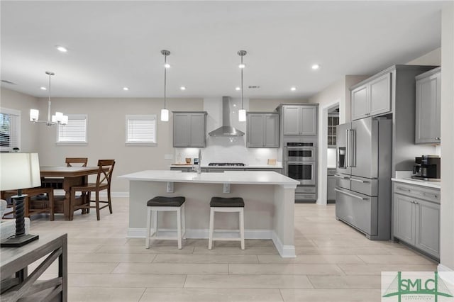 130 Canter Ct, Savannah, GA 31406 - kitchen with appliances with stainless steel finishes, wall chimney exhaust hood, gray cabinets, light countertops, and a kitchen bar
