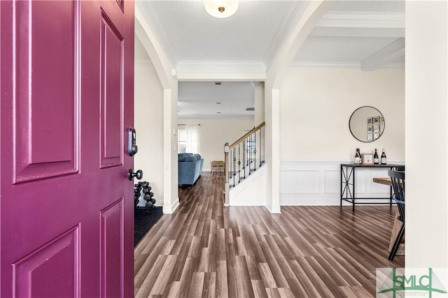 foyer entrance featuring ornamental molding, wood finished floors, and stairway