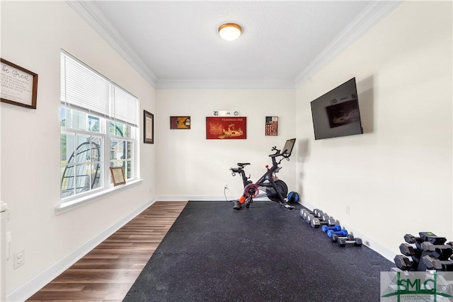 exercise area featuring baseboards, ornamental molding, and dark wood-type flooring