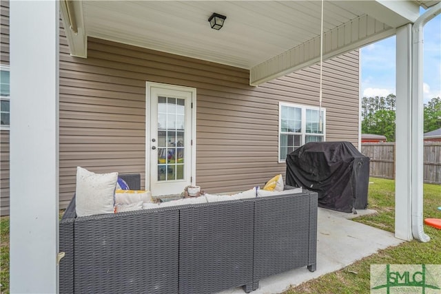 view of patio with area for grilling, fence, and an outdoor living space