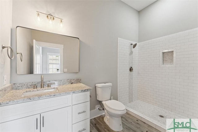 537 E Congress St, Savannah, GA 31401 - bathroom featuring vanity, toilet, tiled shower, and wood finished floors