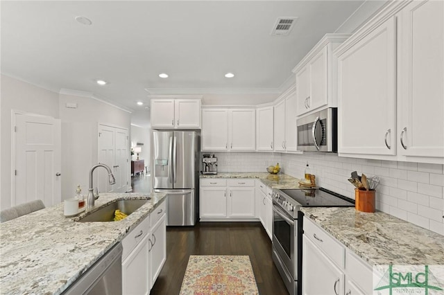kitchen featuring visible vents, dark wood-style floors, white cabinets, a sink, and stainless steel appliances