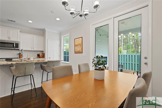 dining room featuring visible vents, ornamental molding, dark wood-type flooring, recessed lighting, and a chandelier