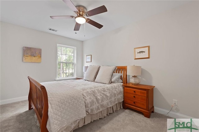 carpeted bedroom featuring baseboards, a ceiling fan, and visible vents