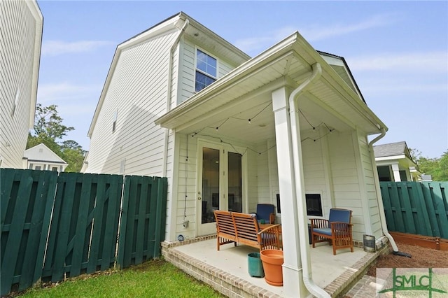 rear view of house with fence and a patio area
