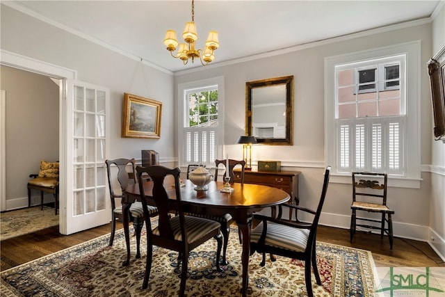 dining area with an inviting chandelier, ornamental molding, baseboards, and wood finished floors
