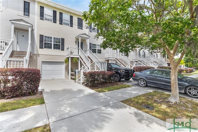 multi unit property with stairs, an attached garage, and concrete driveway