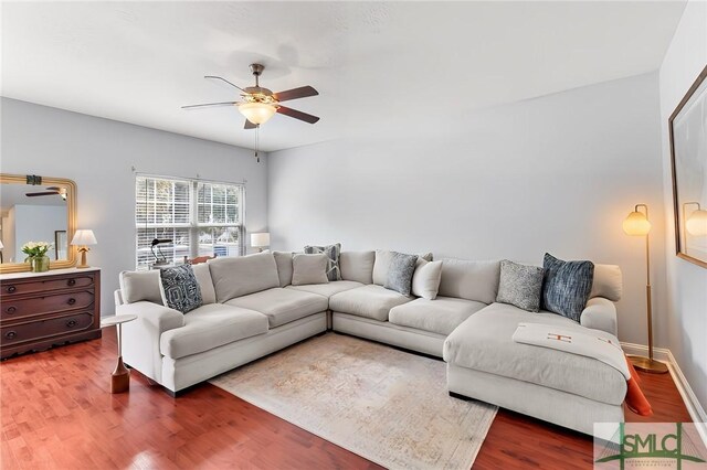 living area with baseboards, ceiling fan, and wood finished floors