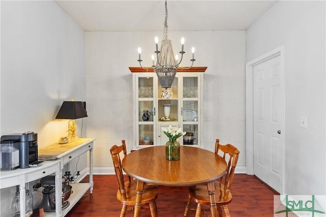 dining area featuring an inviting chandelier, baseboards, and wood finished floors