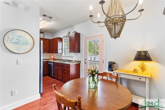 dining area featuring baseboards, visible vents, wood finished floors, and a notable chandelier