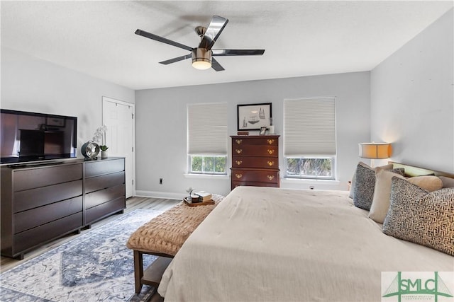 bedroom featuring baseboards, ceiling fan, and wood finished floors