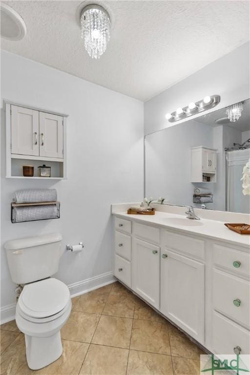 bathroom featuring baseboards, vanity, tile patterned floors, and a textured ceiling