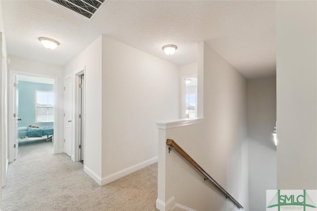 4 Rimes Ave SE, Ludowici, GA 31316 - corridor featuring light carpet, a textured ceiling, baseboards, an upstairs landing, and visible vents