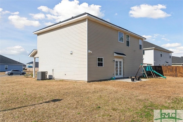 4 Rimes Ave SE, Ludowici, GA 31316 - rear view of house with french doors, central air condition unit, fence, a playground, and a yard