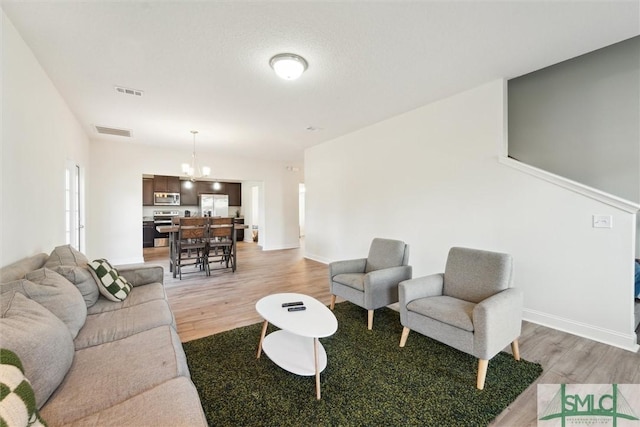 4 Rimes Ave SE, Ludowici, GA 31316 - living room with a notable chandelier, light wood-type flooring, and visible vents