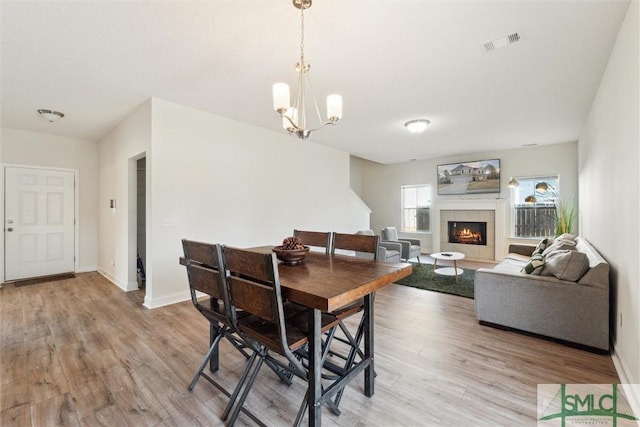 4 Rimes Ave SE, Ludowici, GA 31316 - dining room with a chandelier, visible vents, light wood-style flooring, and a fireplace