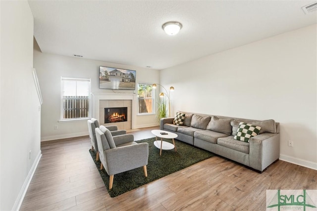 4 Rimes Ave SE, Ludowici, GA 31316 - living area with visible vents, baseboards, wood finished floors, and a tiled fireplace