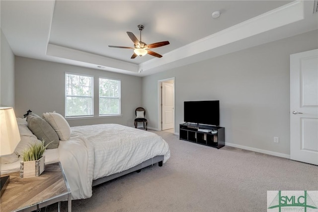 bedroom featuring light colored carpet, a ceiling fan, baseboards, a tray ceiling, and visible vents