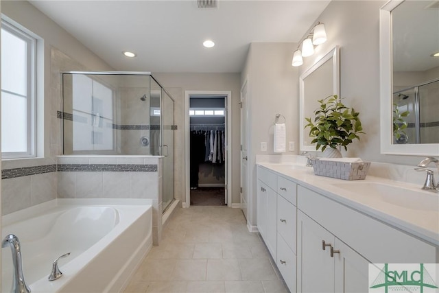bathroom with double vanity, a shower stall, a sink, and a bath