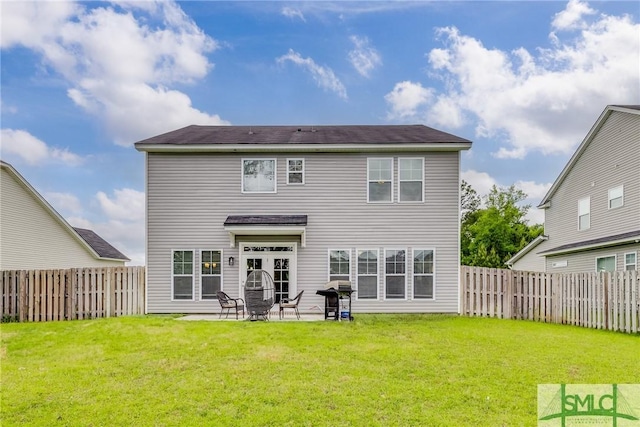 rear view of house with a fenced backyard, a patio area, and a yard