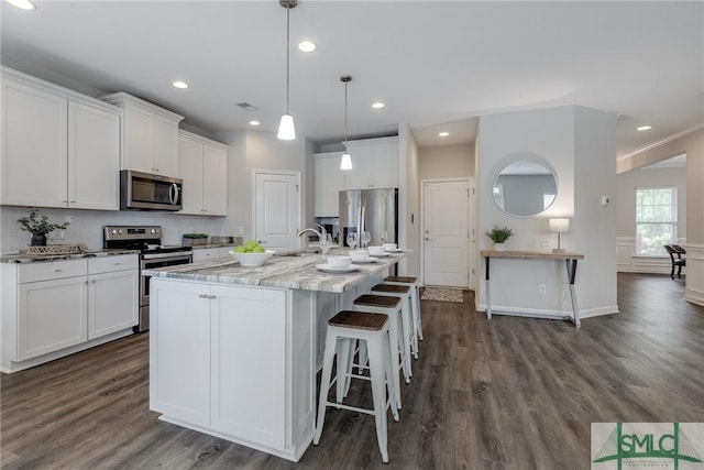 kitchen featuring white cabinets, dark wood-style flooring, appliances with stainless steel finishes, and a sink