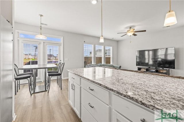 227 Flagler Dr, Savannah, GA 31419 - kitchen featuring open floor plan, light wood-type flooring, white cabinetry, light stone counters, and a ceiling fan