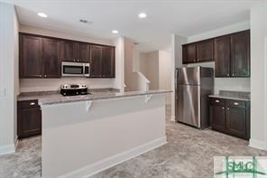 kitchen with dark brown cabinetry, appliances with stainless steel finishes, recessed lighting, baseboards, and a center island with sink