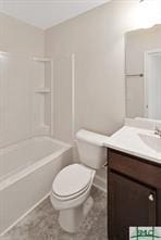 bathroom featuring toilet, washtub / shower combination, and vanity