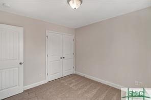 unfurnished bedroom with baseboards and a closet