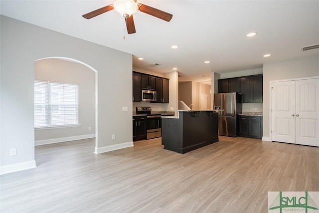 270 Kepler Loop, Richmond Hill, GA 31324 - kitchen featuring appliances with stainless steel finishes, ceiling fan, light wood finished floors, an island with sink, and baseboards