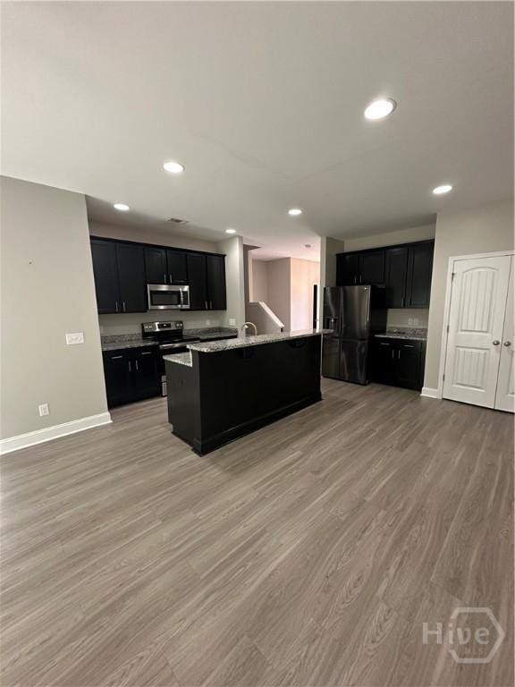 270 Kepler Loop, Richmond Hill, GA 31324 - kitchen with appliances with stainless steel finishes, dark cabinets, light wood-type flooring, baseboards, and recessed lighting