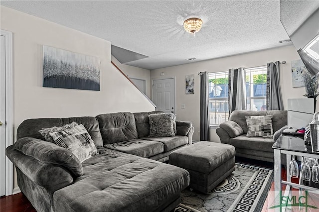 living room featuring a textured ceiling, wood finished floors, and visible vents