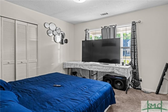 bedroom featuring a textured ceiling, visible vents, baseboards, a closet, and carpet