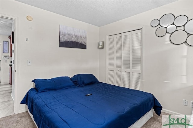 bedroom featuring a textured ceiling, baseboards, carpet, and a closet
