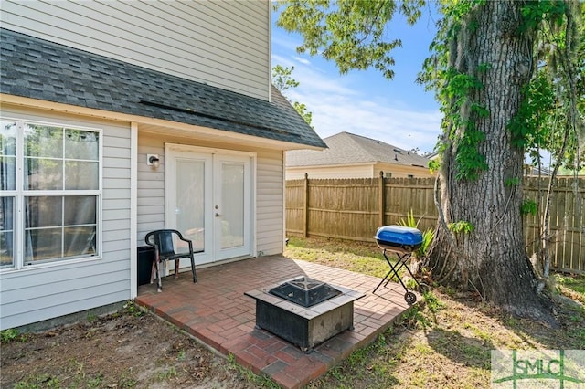 view of patio / terrace with french doors, a fire pit, and a fenced backyard