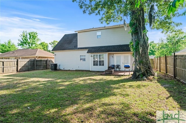 rear view of property with a yard, cooling unit, a fenced backyard, and a patio area