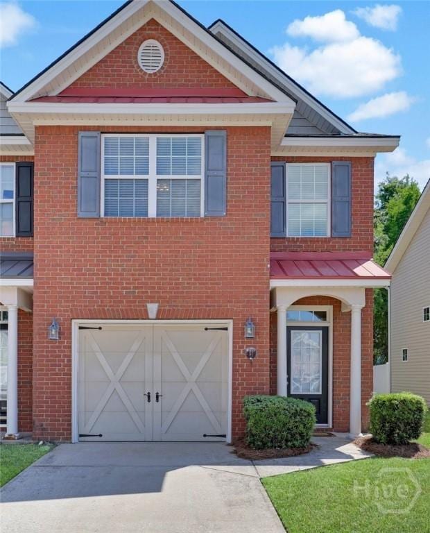 777 King George Blvd Unit 57, Savannah, GA 31419 - view of front facade with a garage, brick siding, driveway, a standing seam roof, and metal roof