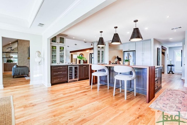 16 Modena Island Dr, Savannah, GA 31411 - kitchen featuring wine cooler, stainless steel refrigerator, a kitchen bar, light countertops, and light wood-type flooring