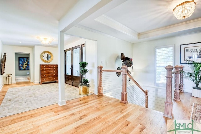 entrance foyer featuring baseboards, crown molding, and light wood-type flooring