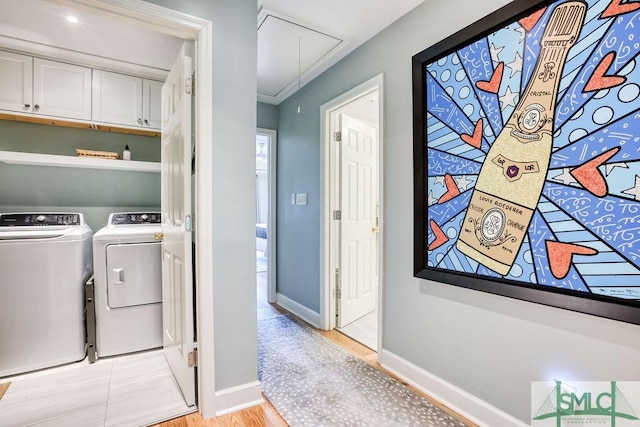 laundry area with washing machine and clothes dryer, baseboards, light wood-style flooring, and attic access