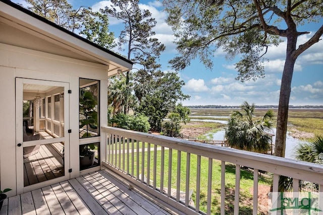 deck with a water view and a yard