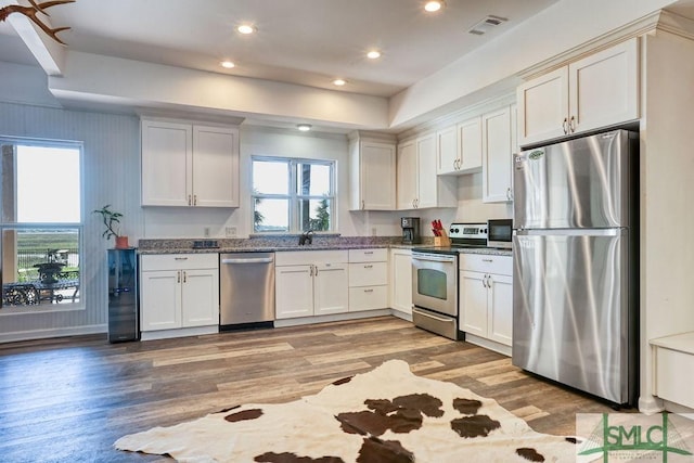 kitchen featuring light wood-style floors, white cabinetry, visible vents, and appliances with stainless steel finishes