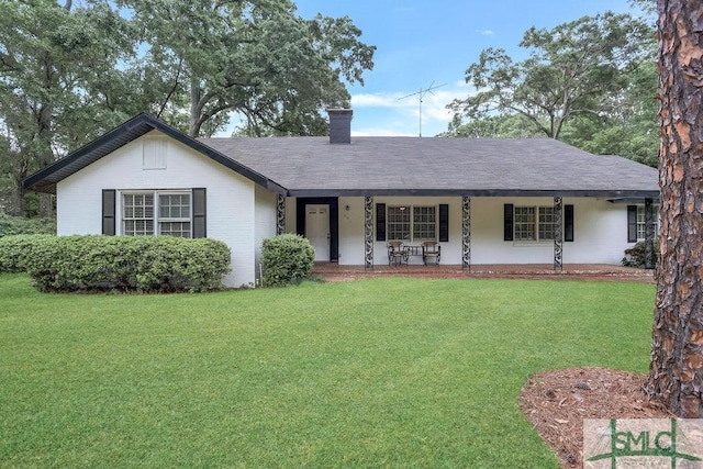 ranch-style house featuring covered porch, a chimney, and a front yard