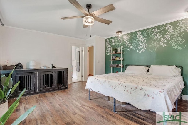 bedroom featuring ceiling fan, ornamental molding, and wood finished floors